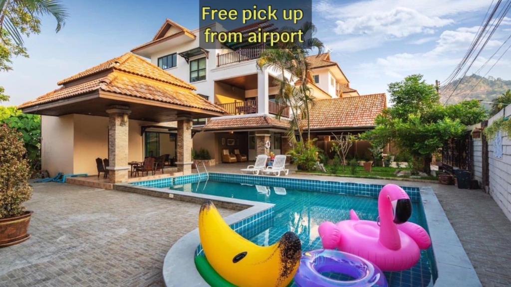 una casa con una piscina con un montón de plátanos inflables en Angel Pool Villa Phuket - SHA Exta Plus, en Phuket