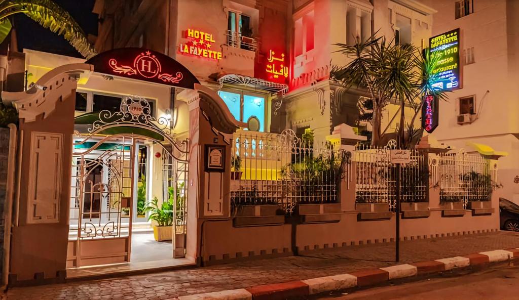 una entrada a un edificio por la noche con letreros de neón en HOTEL LAFAYETTE, en Túnez