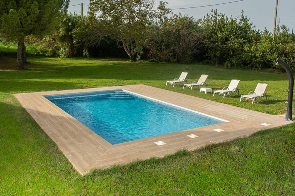 a swimming pool with lounge chairs in a yard at Casa Rural en Rupià con piscina in Rupiá