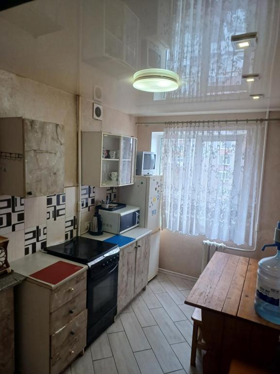 una cucina con lavandino e piano cottura forno superiore di Апартаменти Іва з окремими кімнатами в самому центрі a Dnipro