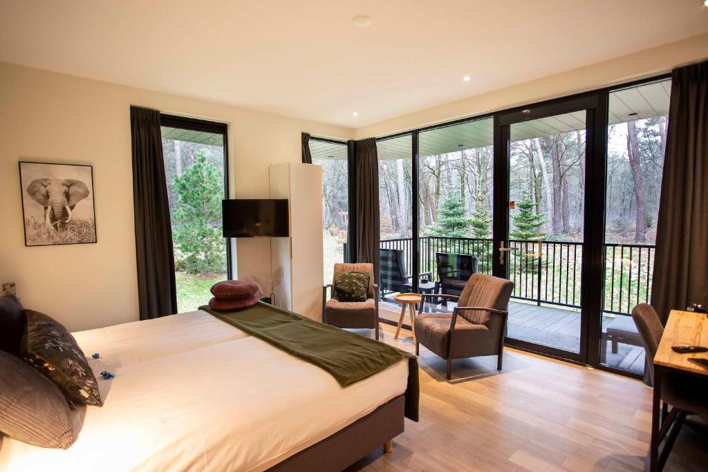 1 dormitorio con 1 cama grande y balcón en Boutique Hotel Bed&Bos, en Best