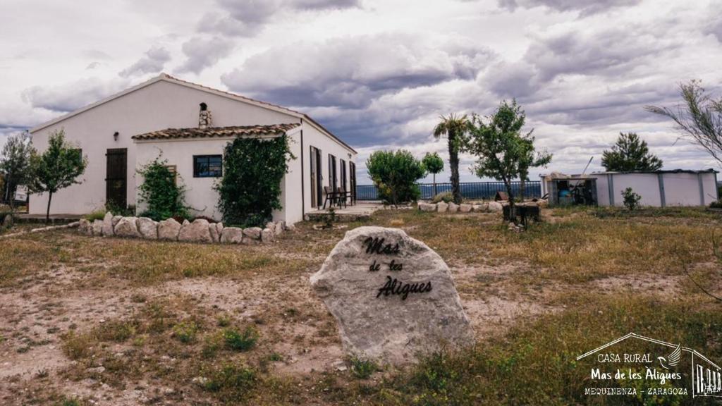 a house with a rock in front of a building at Casa Rural Mas de les Àligues in Mequinenza
