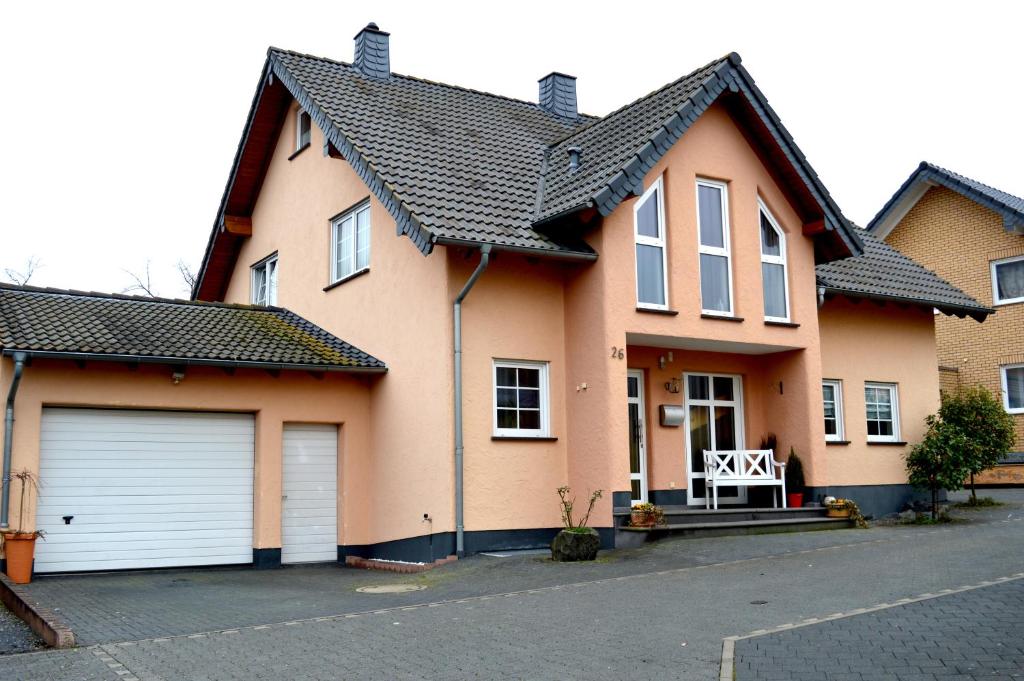 una casa con dos puertas de garaje en una calle en Ferienwohnung Ela 1, en Andernach