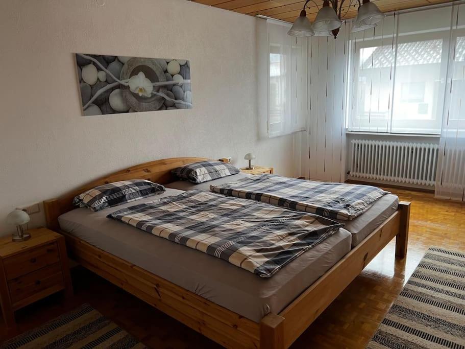 1 dormitorio con 1 cama grande de madera en una habitación en Ferienwohnung Makar, en Burladingen