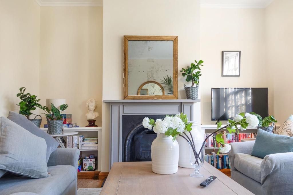 a living room with a vase of flowers on a coffee table at Cheerful 3 bedroom luxury house in London