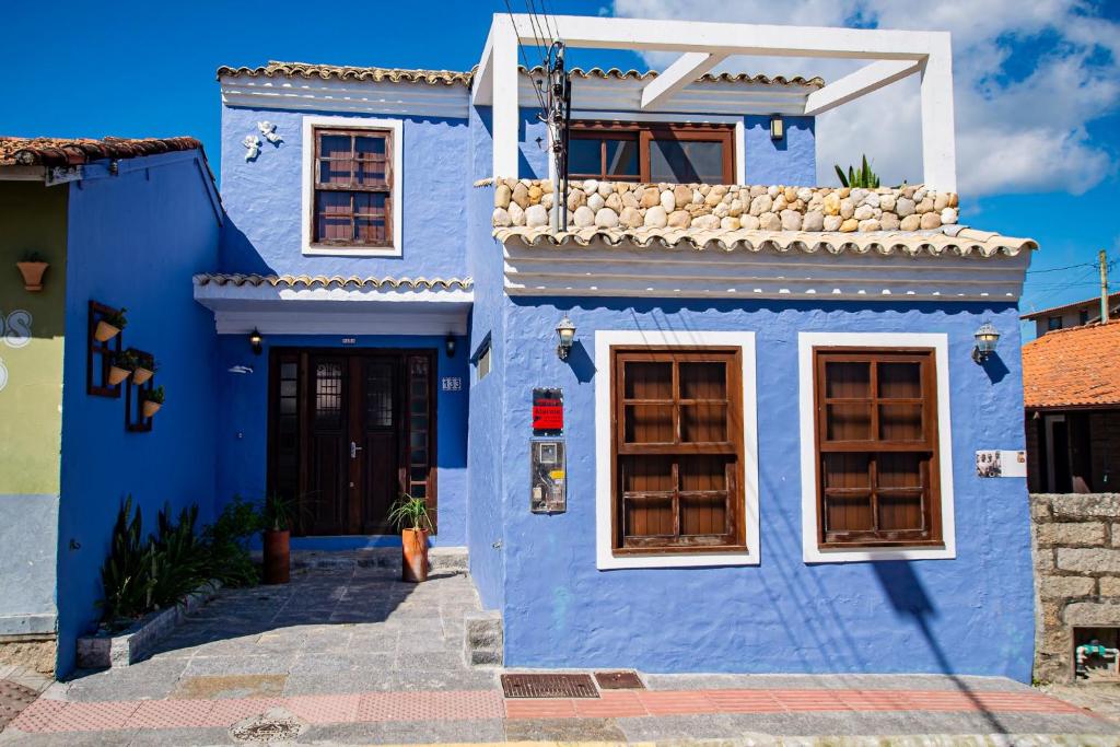 un edificio azul con ventanas y una puerta en Casa Nara, en Garopaba