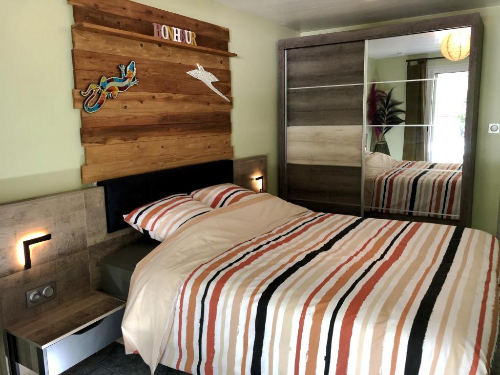 - une chambre avec un lit et un mur en bois dans l'établissement Ti Kaz Furcy, à Saint-Louis