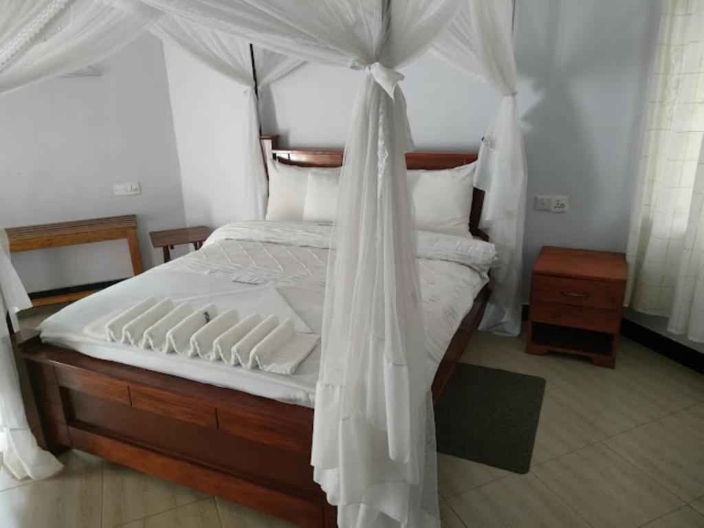 a bedroom with a canopy bed with white sheets and pillows at POAPARK RESORT 