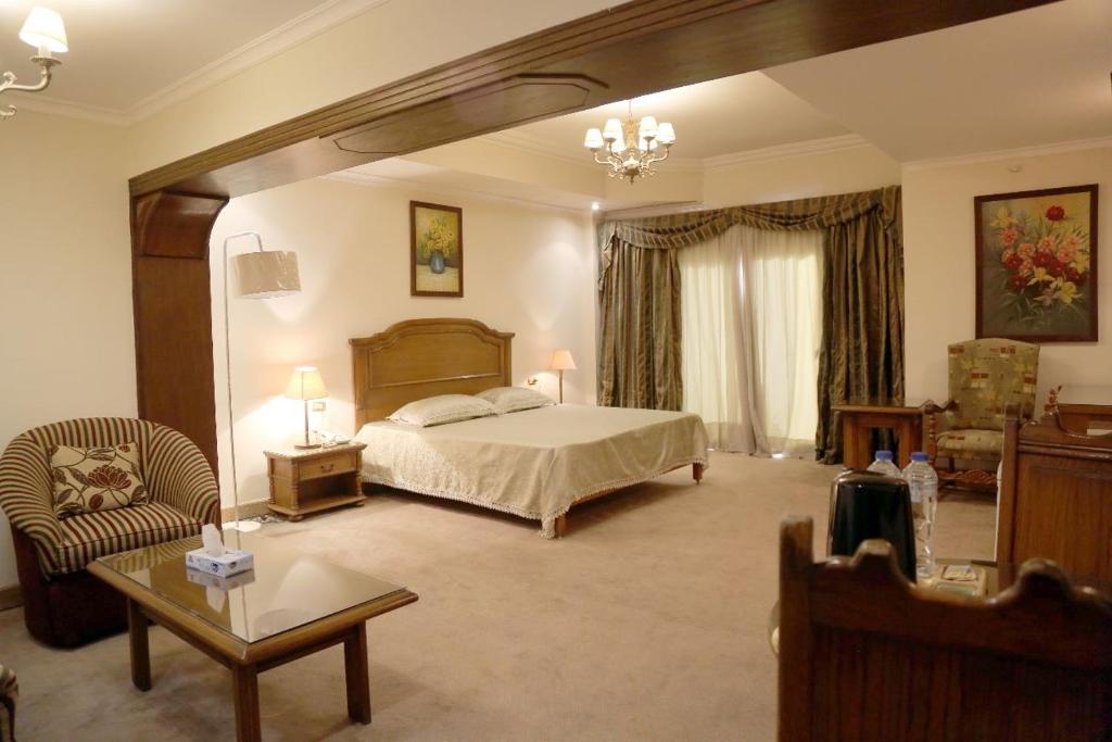Cairo international Scout House في القاهرة: غرفة نوم كبيرة بها سرير وكرسي