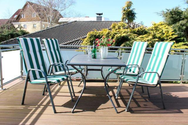 3 sillas y una mesa en una terraza en Ostsee Appartement Grömitz - Haus Ihlow, en Grömitz