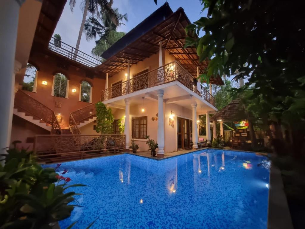 a villa with a swimming pool at night at Mandaram villas in Mararikulam