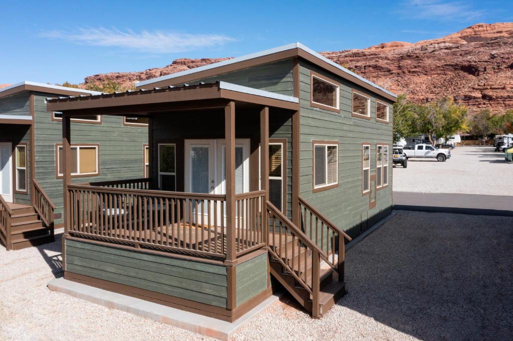 a green tiny house in a parking lot at Sun Outdoors North Moab in Moab