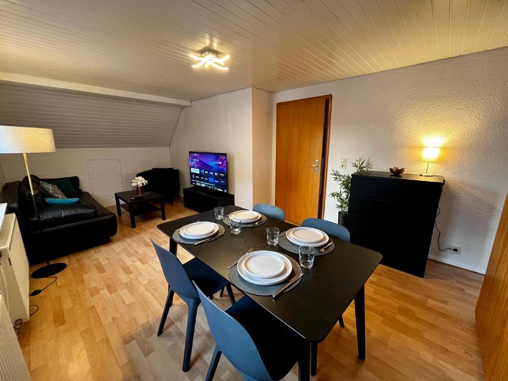 a living room with a table and chairs and a couch at OhPardon! GAILDORF - Monteurwohnung im DG, Einzelbetten, Garten in Gaildorf