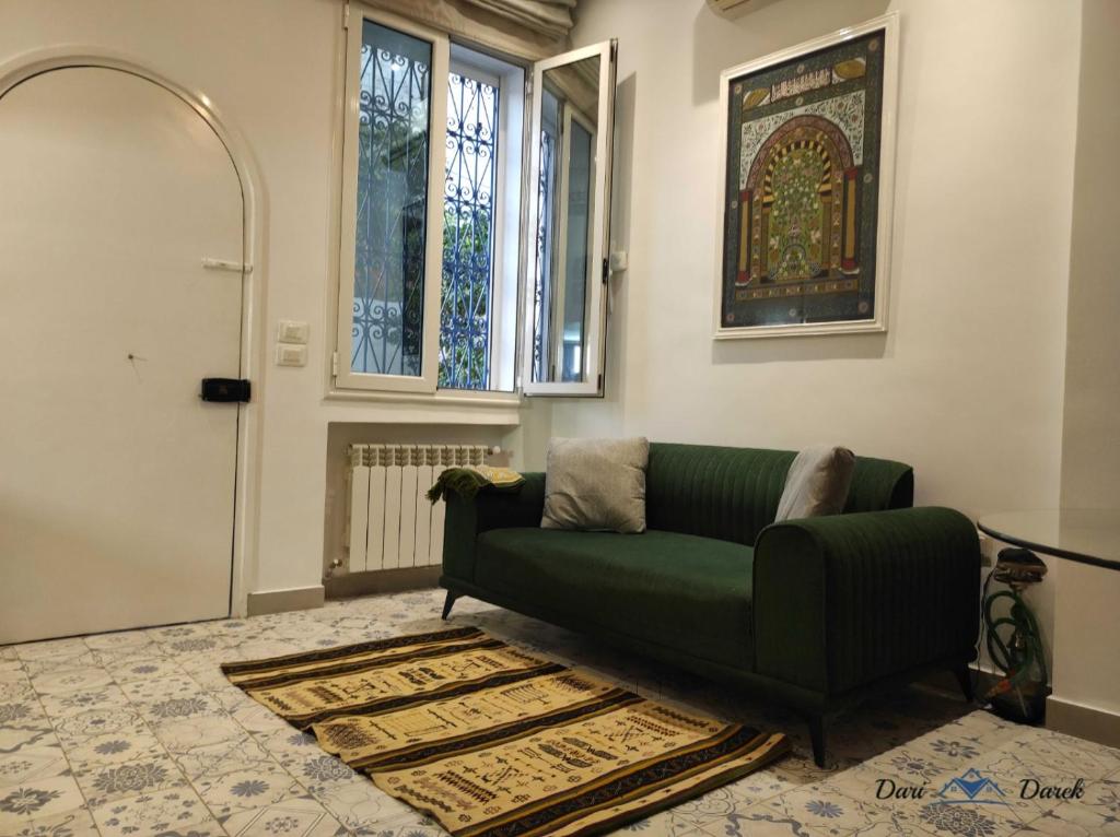 a living room with a green couch and a window at mezzanine in Hammamet