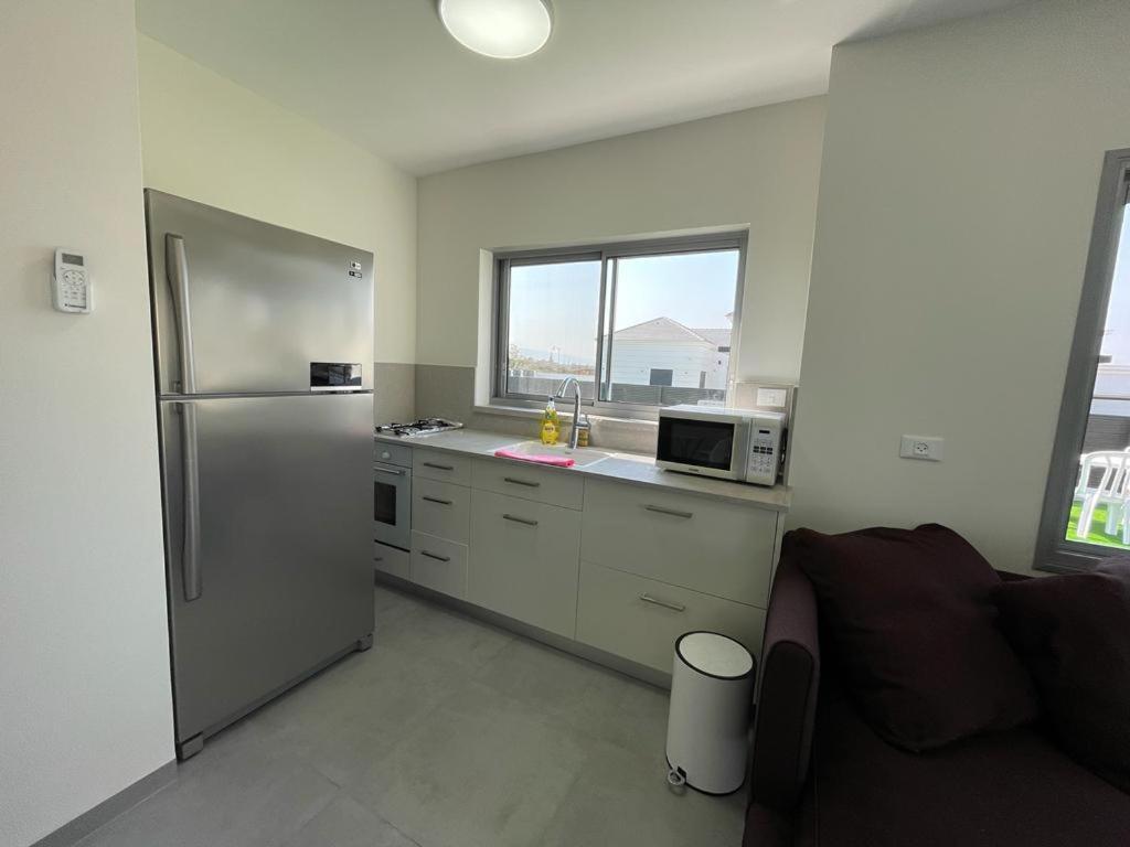 a kitchen with a stainless steel refrigerator and a microwave at משהו בהגושרים- אירוח בגליל in HaGoshrim