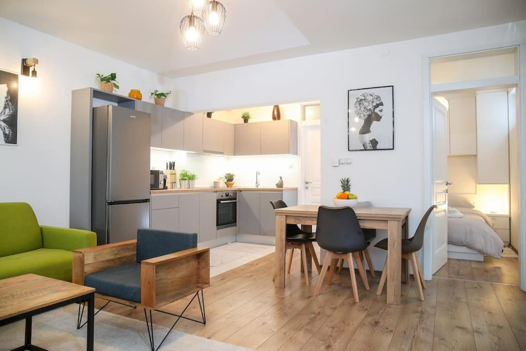 een keuken en een woonkamer met een tafel en stoelen bij Nusha's place in Zagreb
