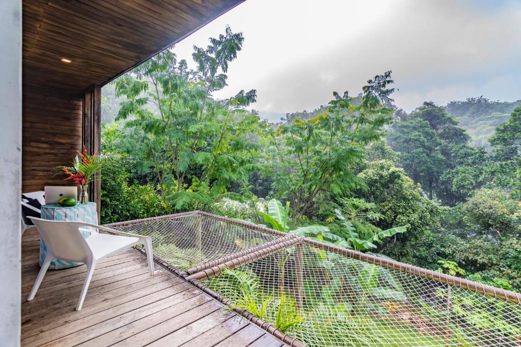 a balcony with a chair and a view of the forest at Sweet Harmony Hotel Boutique by Xarm Hotels in Minca