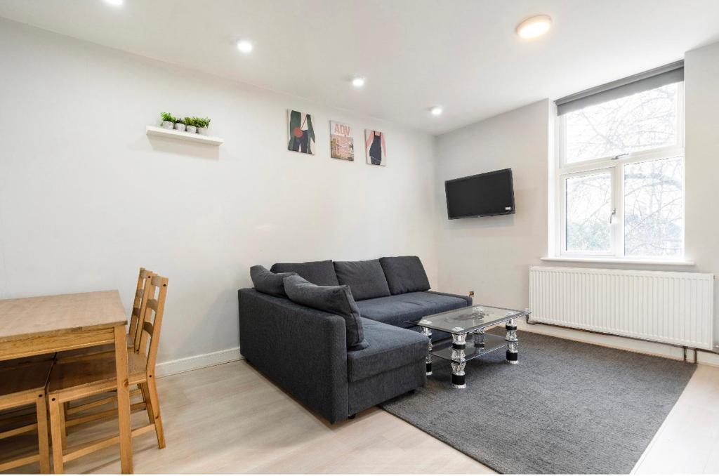 ein Wohnzimmer mit einem Sofa und einem Tisch in der Unterkunft Luxury Flat in Moseley with Free Parking in Birmingham