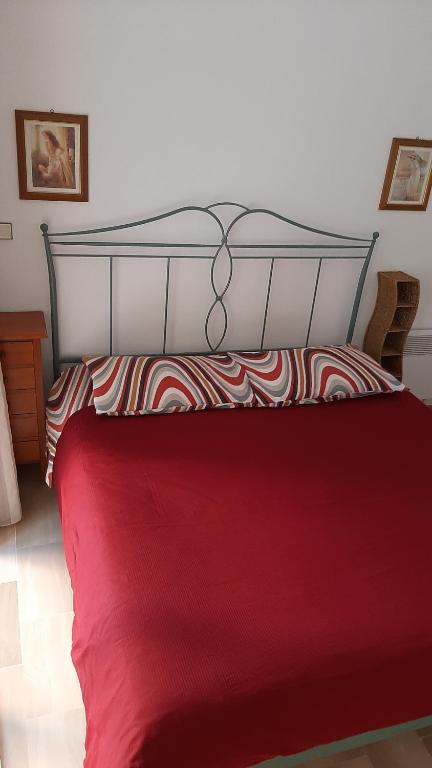 - une chambre avec un lit rouge et une tête de lit en métal dans l'établissement LE GOLF, à Menton