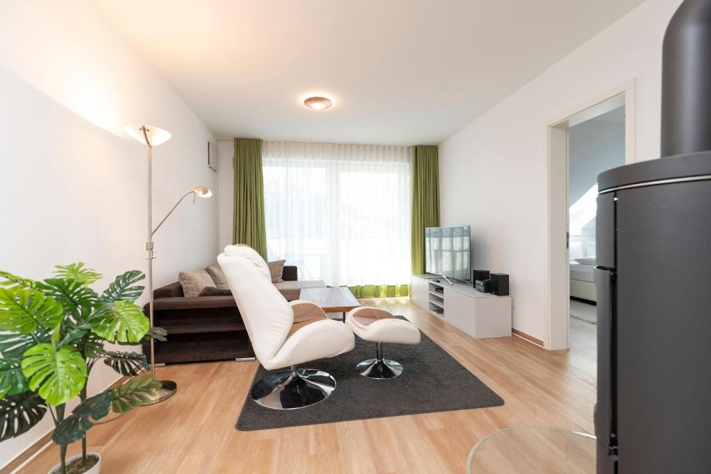 ヘリングスドルフにあるFerienwohnung 08 Villa Eviのリビングルーム(白い椅子2脚、ソファ付)