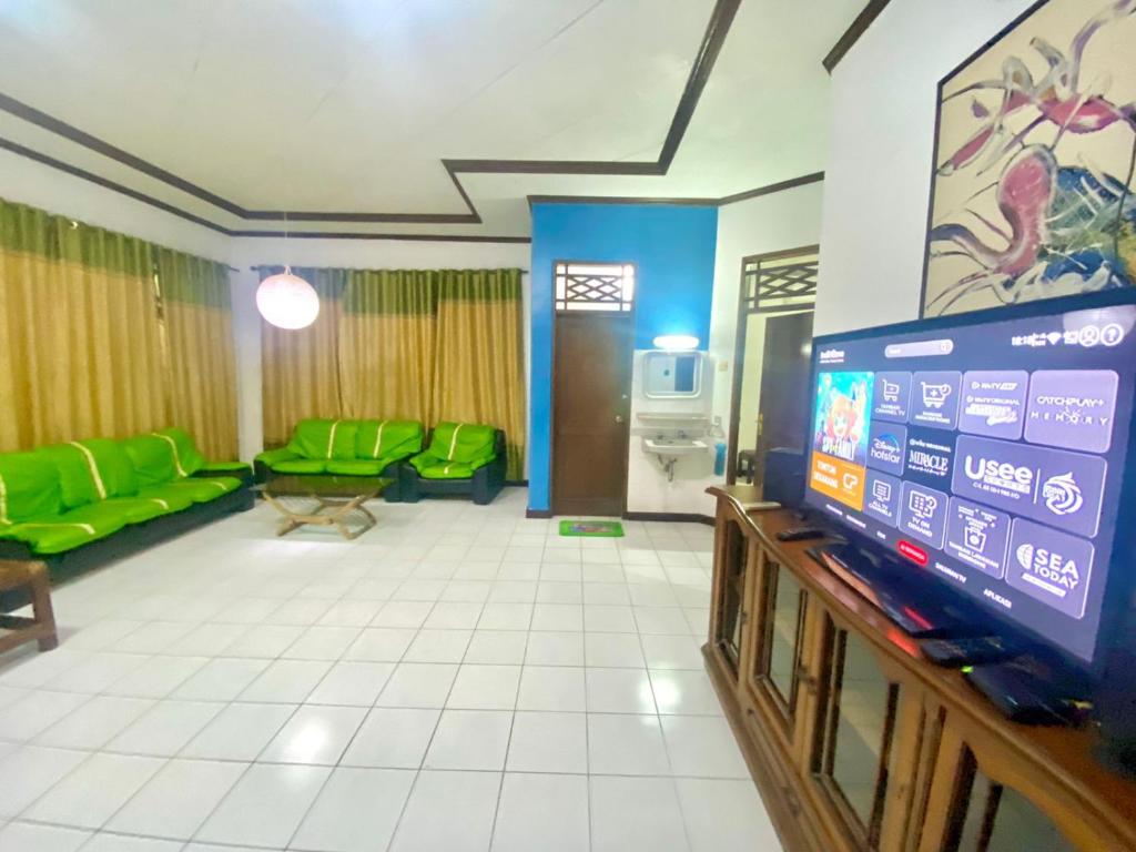 a living room with green furniture and a flat screen tv at Fania Villa in Cinengangirang