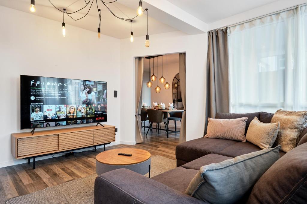 sala de estar con sofá y TV de pantalla plana en Park Avenue - Design Apartment Friesenstraße - 4 Pers - WLAN - Netflix - 65 Zoll TV, en Colonia