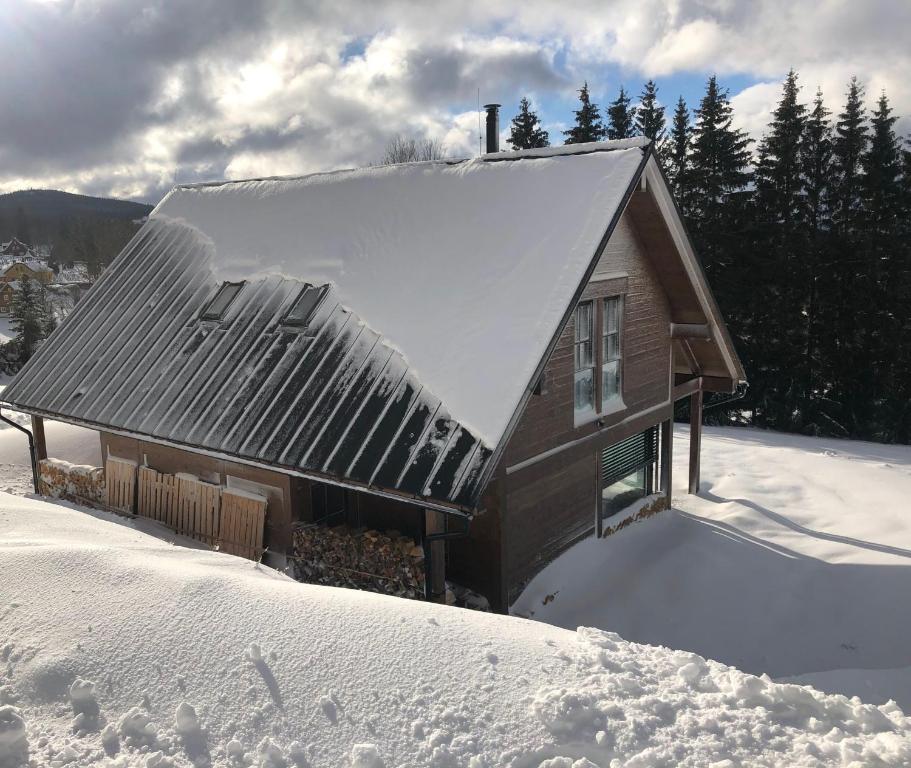 una casa con nieve en el techo en Mountain chalet, en Kořenov