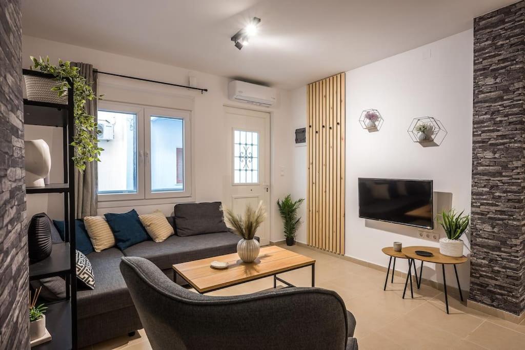 a living room with a couch and a tv at Sofman city center apartment I in Heraklio Town