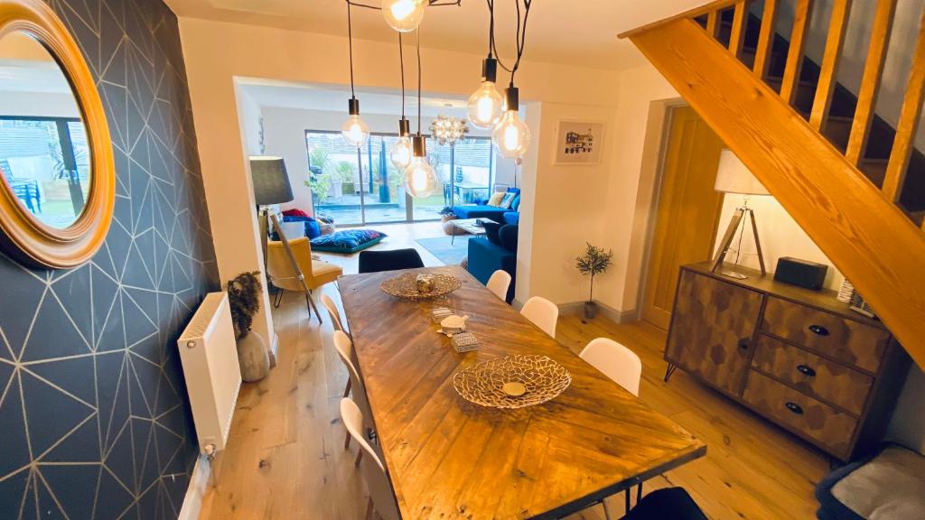 uma sala de jantar com uma mesa de madeira e uma sala de estar em Tregenna House - St Ives, A Beautiful Newly Refurbished 4 Bedroom Family Town House With Alfresco Dining Garden and Private Parking Spaces em St Ives