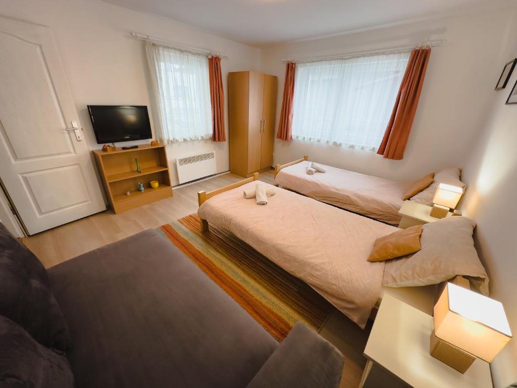 een kleine slaapkamer met 2 bedden en een televisie bij Apartman Lokum in Sarajevo