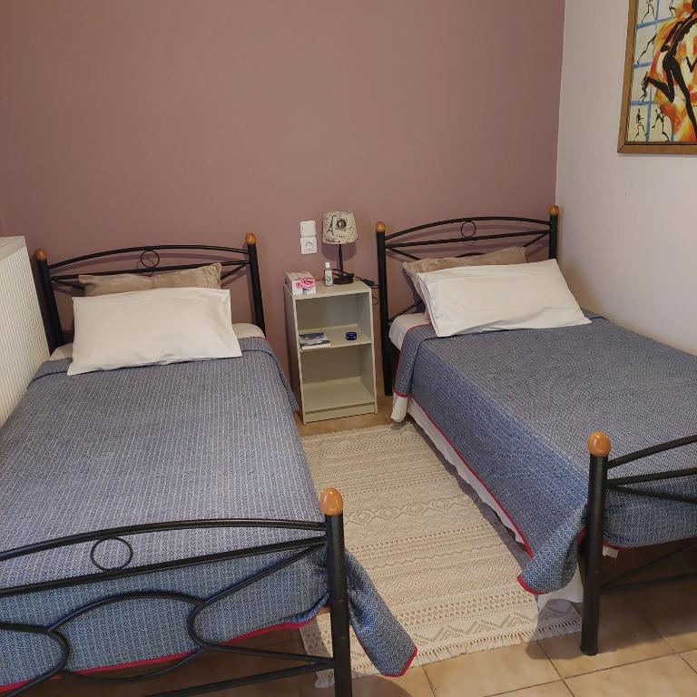 a bedroom with two beds and a night stand at Urban Penthouse in Patra