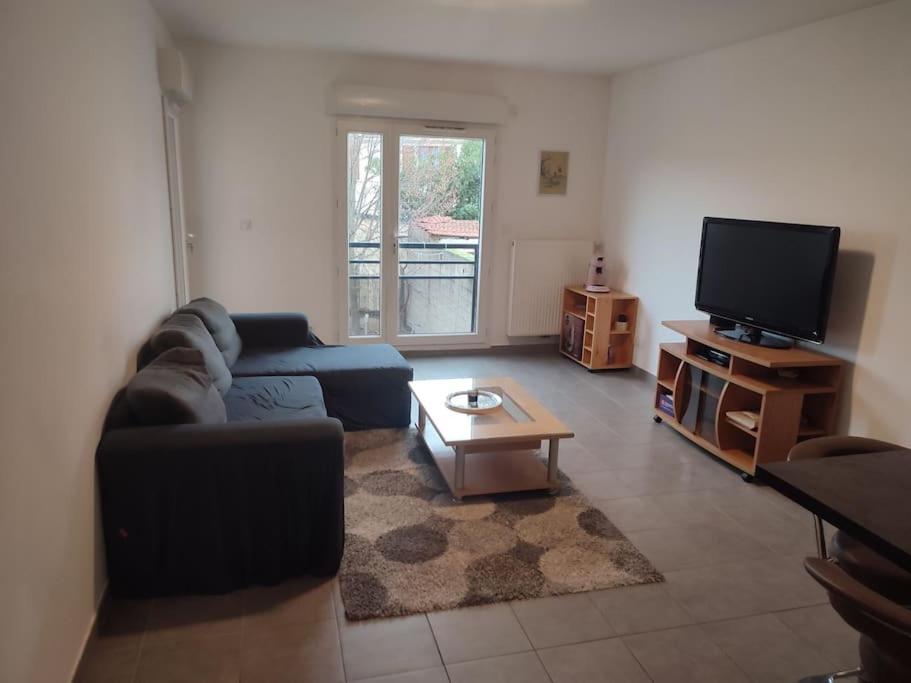 a living room with a couch and a tv at Appartement proche aéroport Orly in Athis-Mons