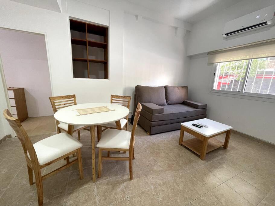 uma sala de estar com uma mesa e um sofá em Hermoso departamento para 4 en la mejor zona de Núñez- Ibera em Buenos Aires