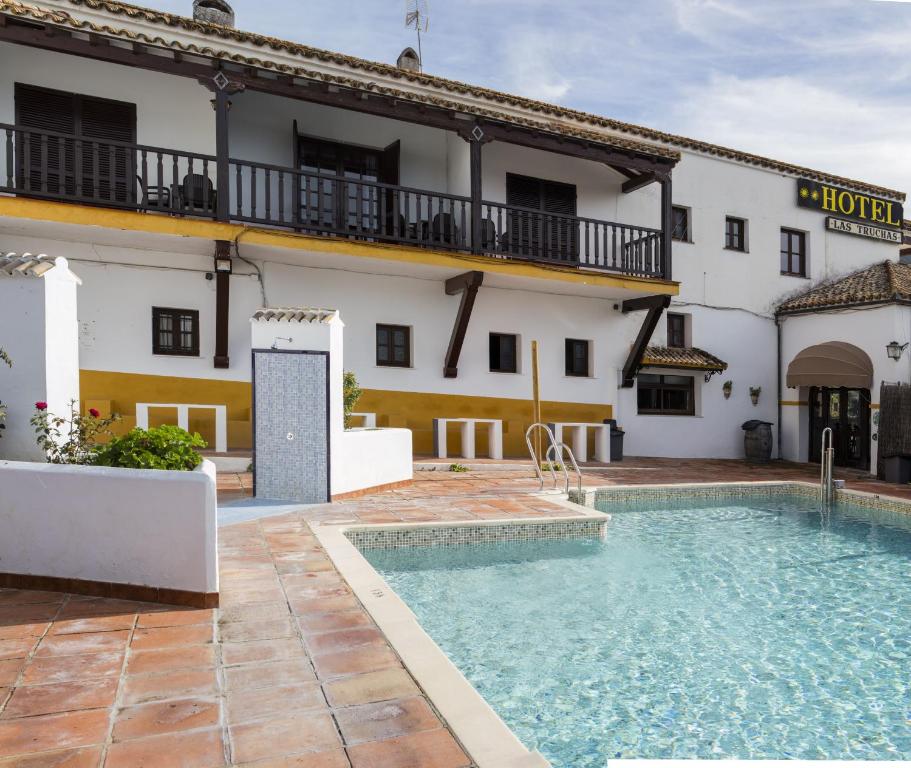 a hotel with a swimming pool in front of a building at Hotel Tugasa Las Truchas in El Bosque