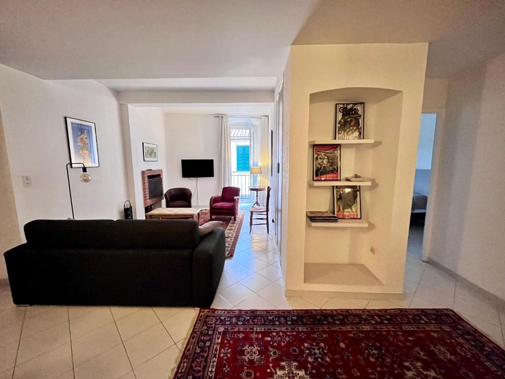 salon z czarną kanapą i czerwonym dywanem w obiekcie Appartement spacieux en face du port w Calvi