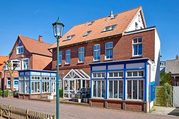 un gran edificio de ladrillo con una luz de la calle delante de él en Aparthotel Domizil, en Borkum