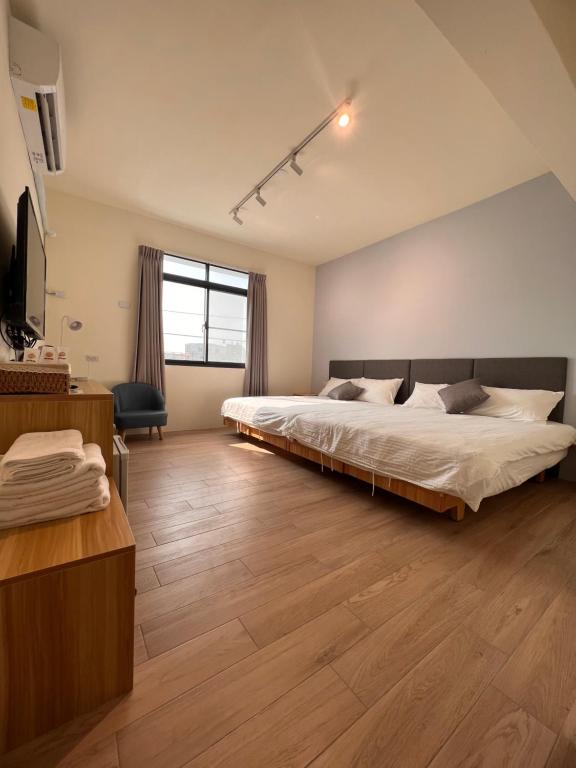um quarto com uma cama grande e uma televisão em 茄萣路科民宿 
