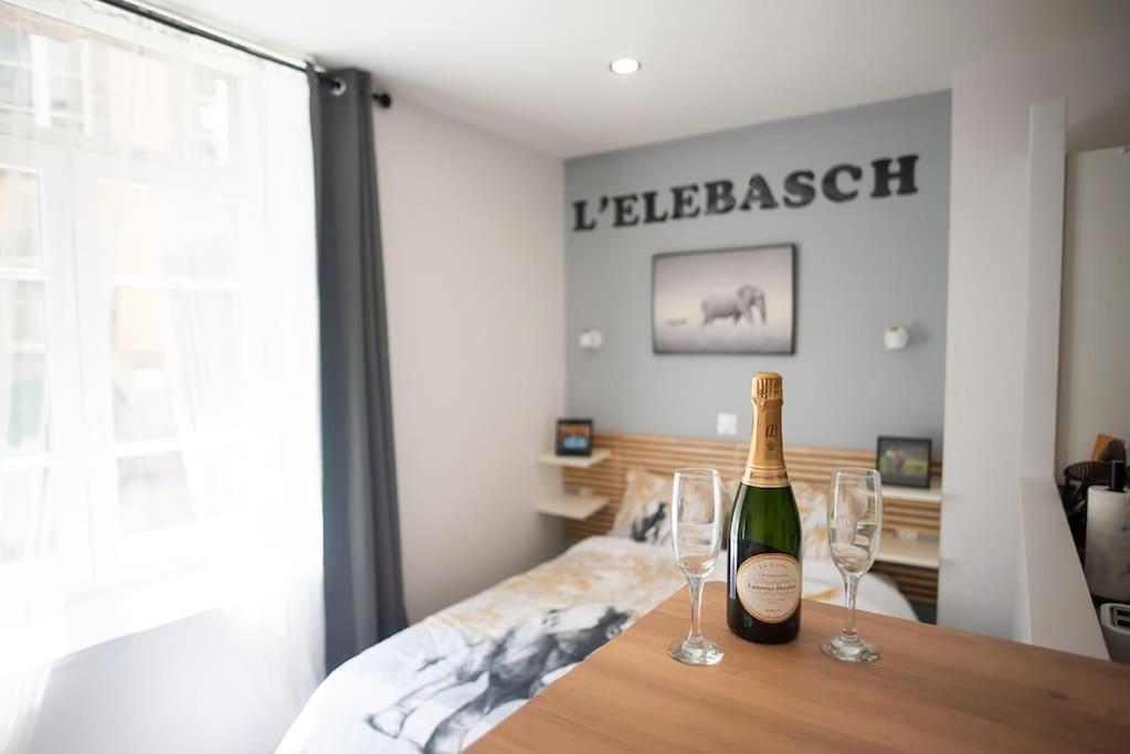 een fles champagne en twee glazen op een tafel bij L'ELEBASCH - Studio confort Netflix/Prime Vidéo in Riom
