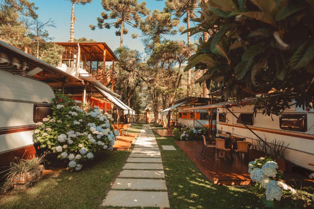 a pathway leading to a train station with flowers at La Brume Trailers in Campos do Jordão