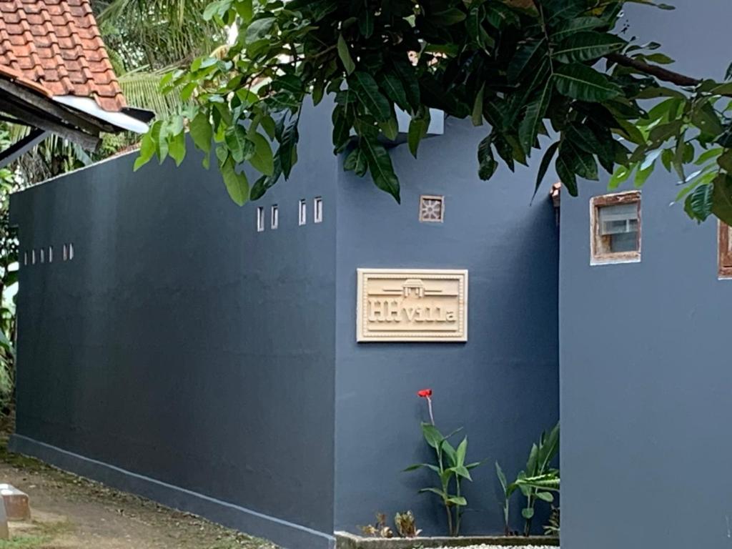un mur bleu avec un signe sur celui-ci dans l'établissement HH Villa, à Rowokele