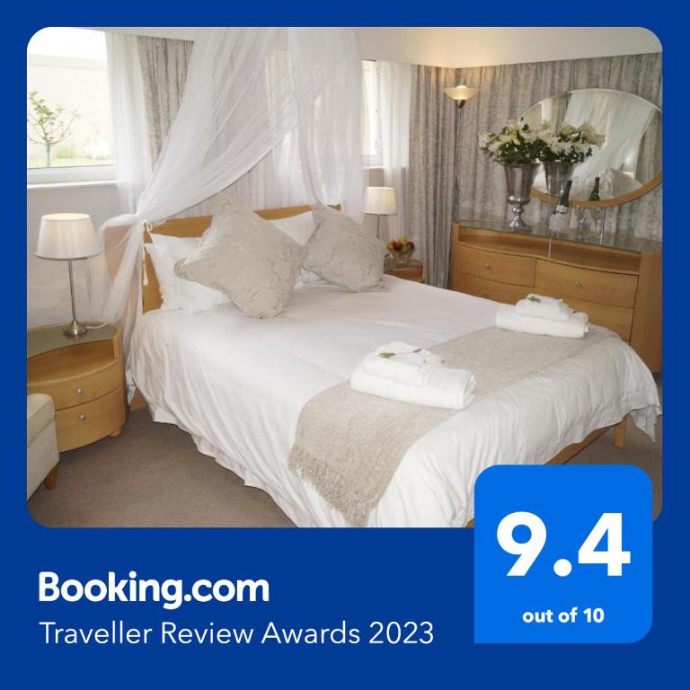 a bedroom with a bed with white sheets and pillows at Valentines Hermanus in Hermanus