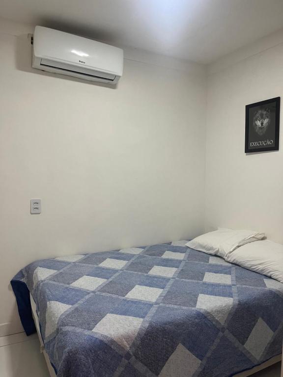 una camera con un letto con una coperta blu e bianca di Apartamento cozzy a Pipa