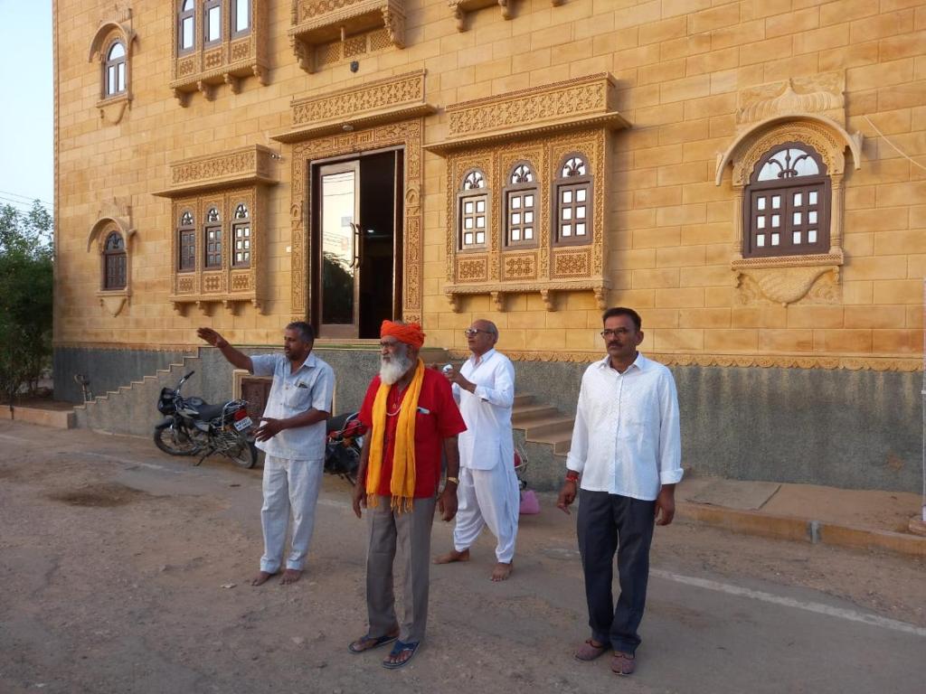 eine Gruppe von Männern, die vor einem Gebäude stehen in der Unterkunft Vamoose Thakurji Palace in Jaisalmer