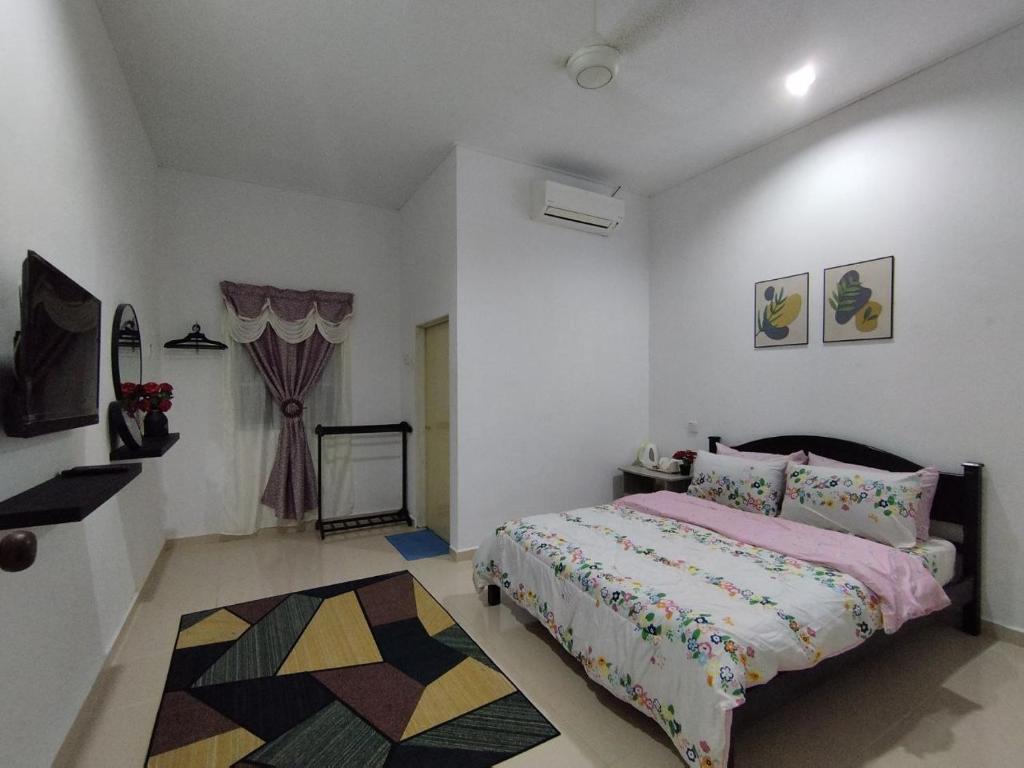 a bedroom with a bed and a rug at Dahliya Roomstay Langkawi in Pantai Cenang