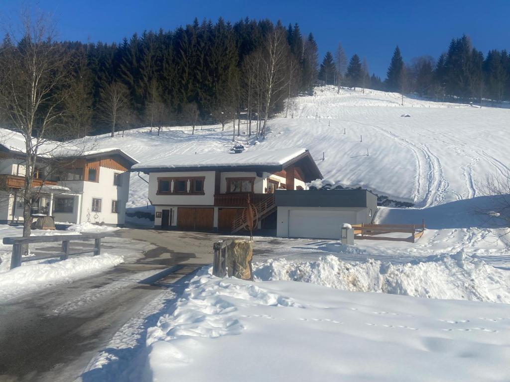 a house in the snow with a snow covered yard at Landhaus Weiss in Sankt Martin am Tennengebirge