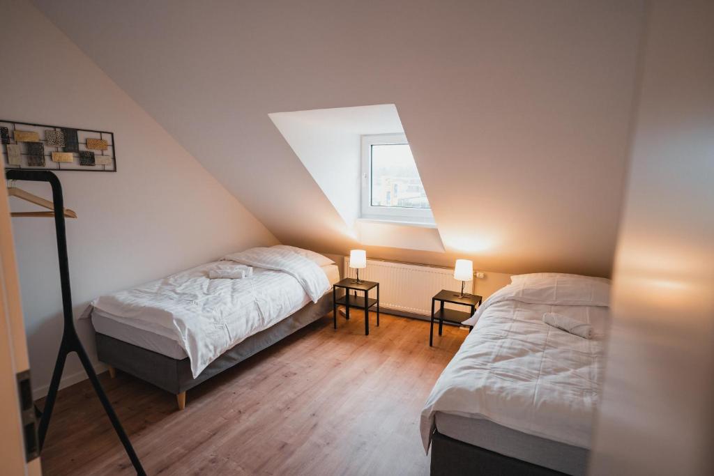 Schlafzimmer im Dachgeschoss mit 2 Betten und einem Fenster in der Unterkunft Working Apartment - 8 single beds - 5 Schlafzimmer in Mönchengladbach