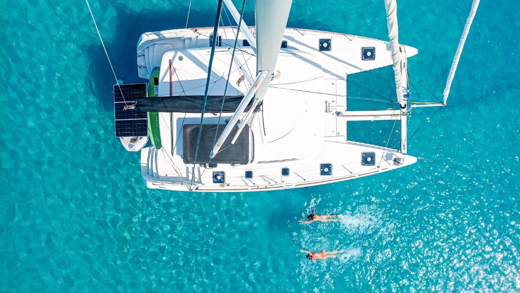 two people swimming on a boat in the water at Croatia by Luxury Catamaran in Split