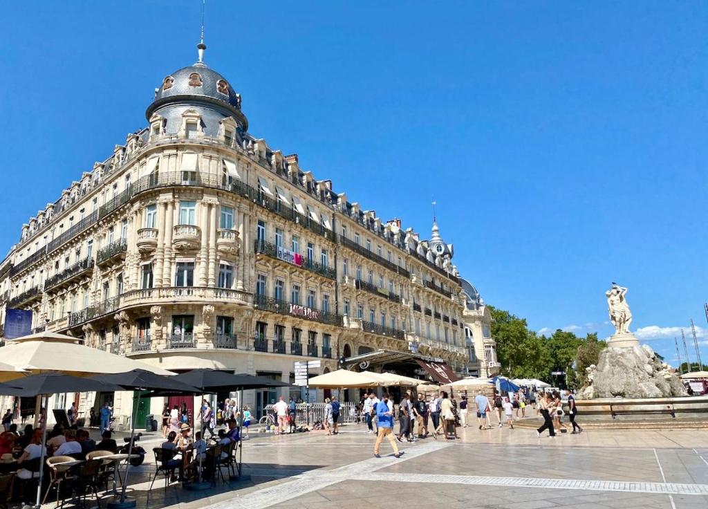 un gran edificio con gente caminando delante de él en Port Marianne City Cosy Apparemment en Montpellier