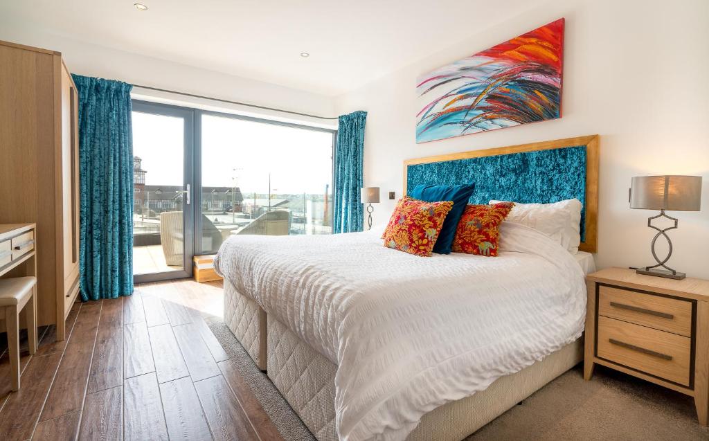 sypialnia z łóżkiem i dużym oknem w obiekcie Antrim House Suites with private jacuzzi hot tub - adults only w mieście Portrush