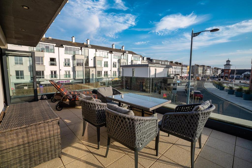 a patio with a table and chairs on a balcony at Antrim House Guest Rooms & Suites in Portrush